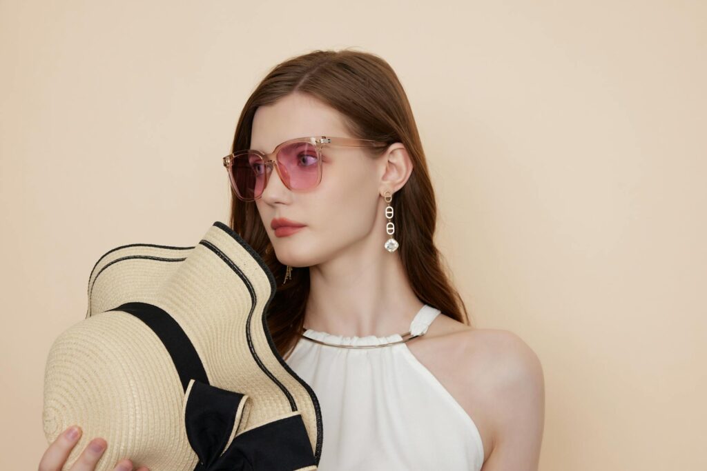 Stylish woman wearing sunglasses and hat, showcasing modern fashion sense.