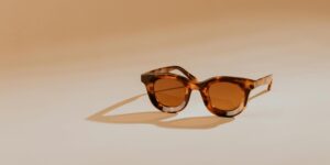 Elegant tortoise shell sunglasses resting on a warm beige background.